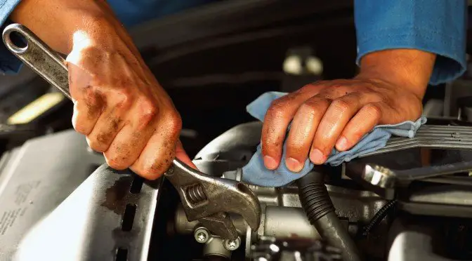 Auto mechanic working on car engine at one of the best garages in Nairobi