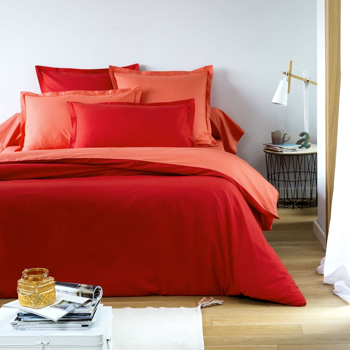 A bed made up in red tones