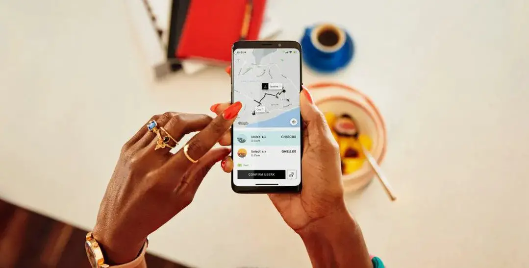 African female hands holding a phone with the Uber app