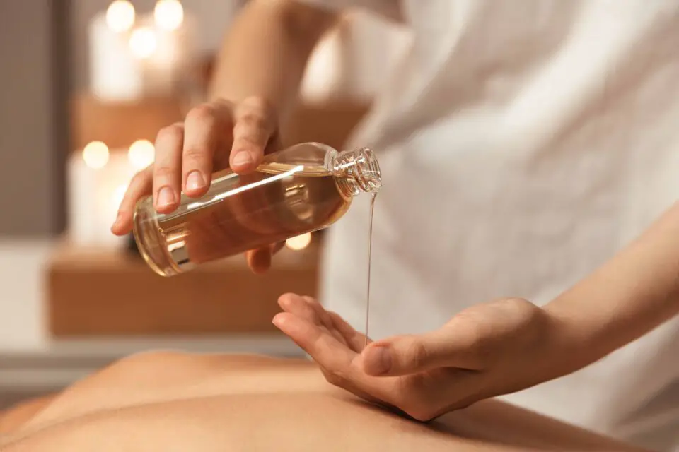 Massage body oil being poured from a bottle