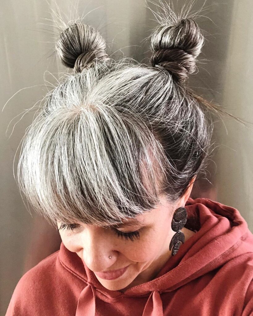 Best Hairstyles for Growing Out Gray Hair: space buns with a fringe